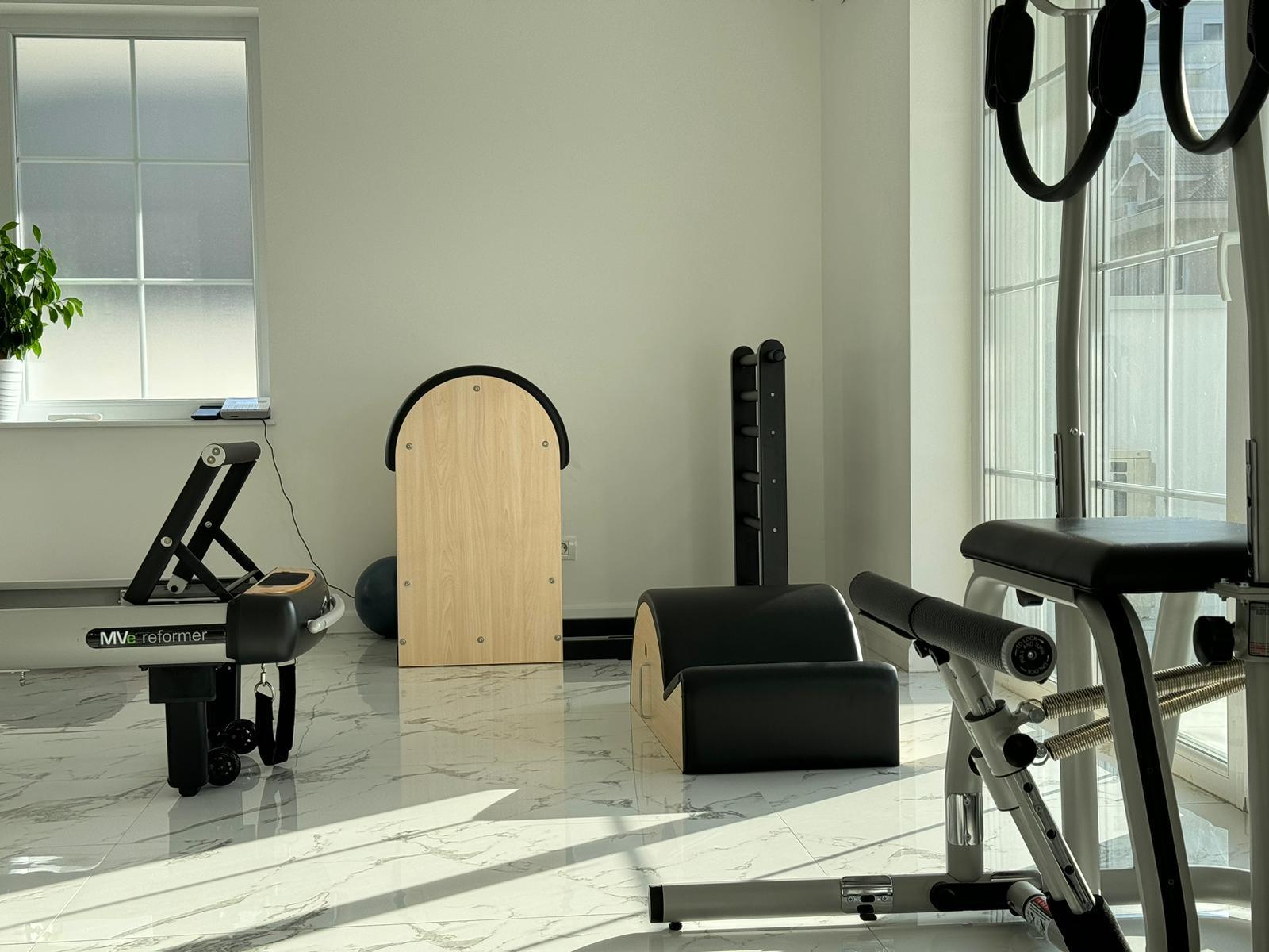 Sala de Pilates cu aparatele aliniate pe podeaua de marmură