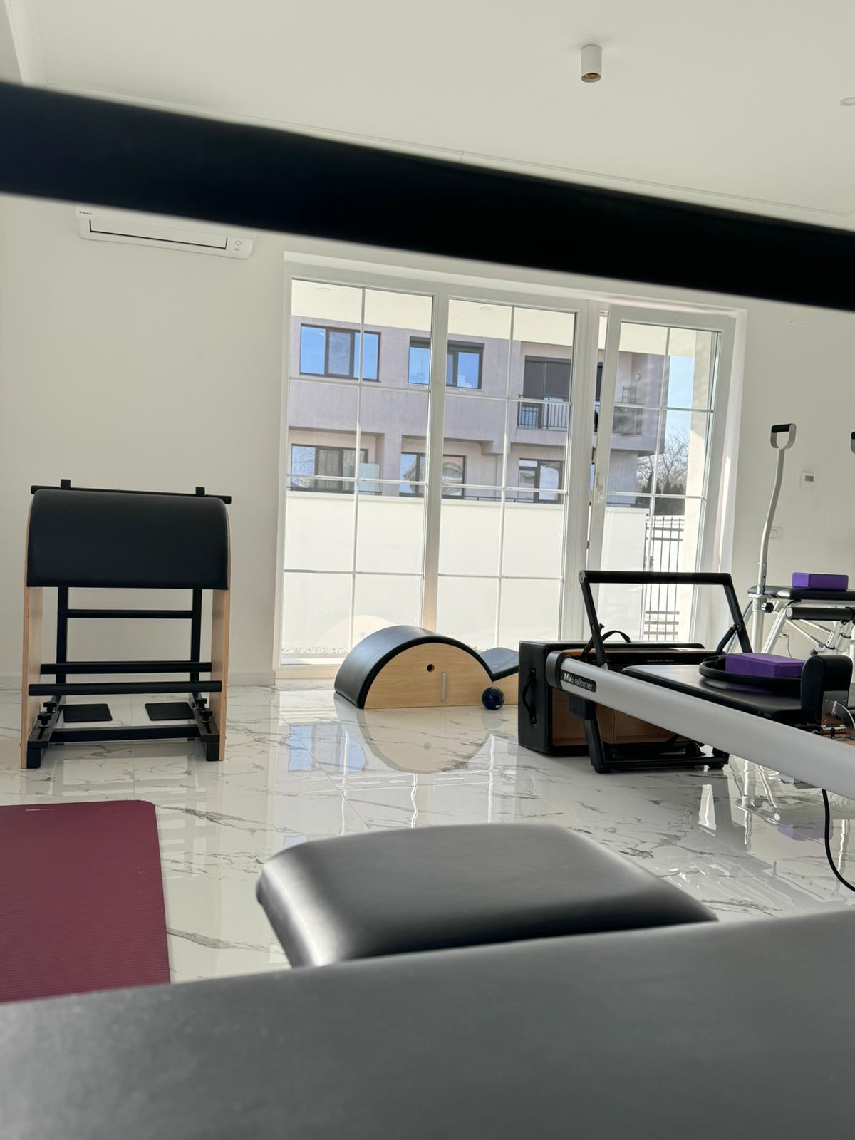 Studioul Harmonify Pilates cu chair, arc și reformere, în lumina ferestrelor